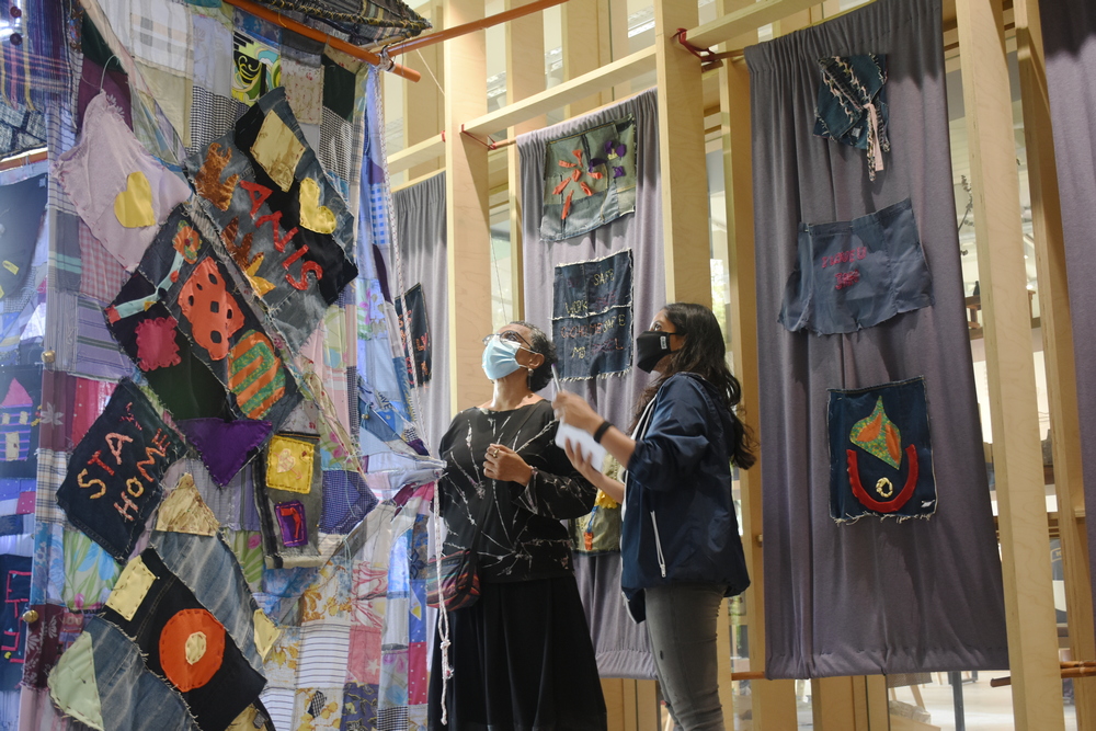 An art college student (left) is sharing about the origin and objective of the art project to a participant on the open day. (Photo by Wong Siew Kuen) 