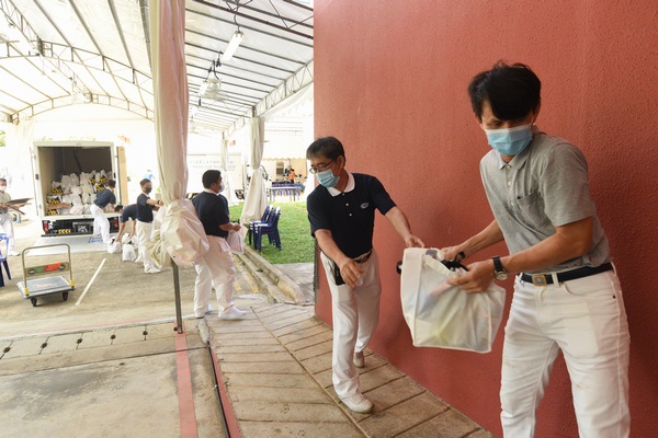 Volunteers are passing the gift packages to be delivered to the isolation facility.