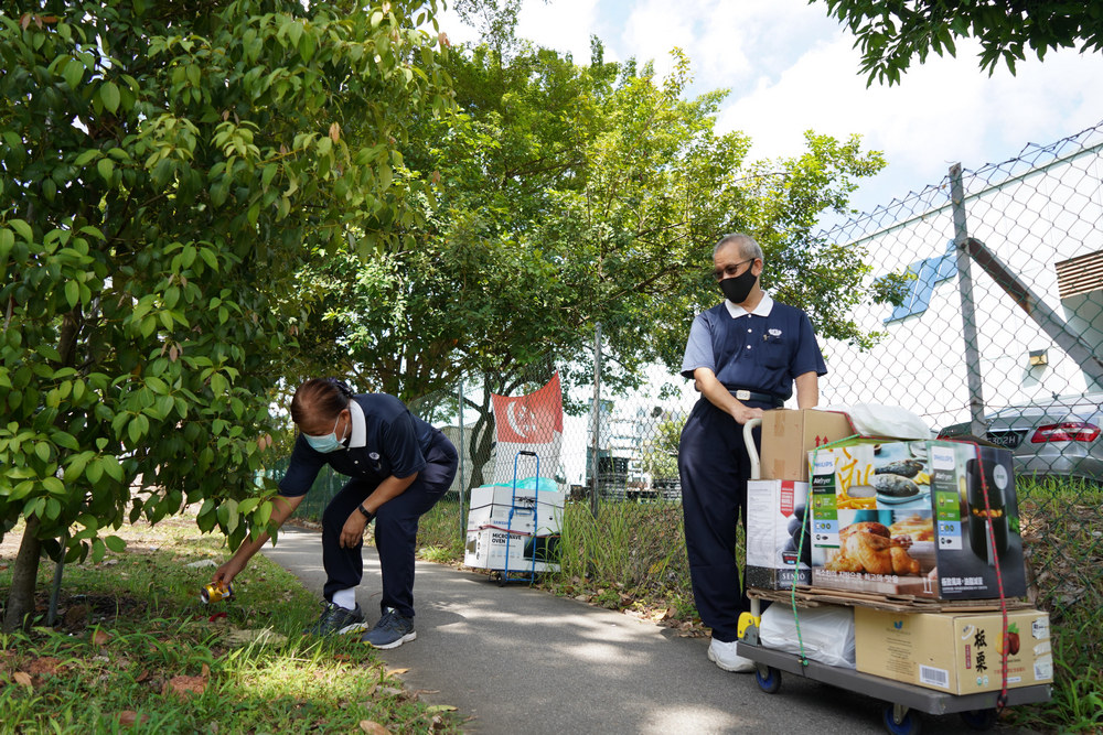 Ms Ng stopping to pick up an aluminium can en-route to the Centre. (Photo by Chan May Ching)